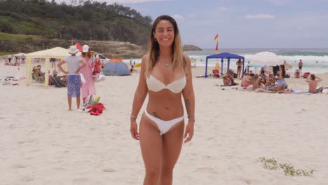 Chica-Con-Bikini-Blanco-Durante-Una-Escapada-De-Verano-Con-Muchos-Vacacionistas-En-La-Orilla-Arenosa-De-La-Playa-De-South-Gorge-En-North-Stradbroke-Island,-Queensland,-Australia