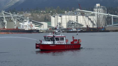Feuerwehrmann-Steht-Am-Vancouver-löschboot,-Während-Er-Wasser-Am-Burrard-einlass-In-Vancouver,-Kanada,-Sprüht