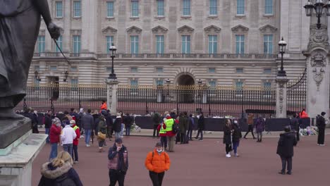Buckingham-Palace-wide-shot-of-Union-Jack-flying-at-half-mast-and-mourners-gathered-to-mark-the-death-of-Prince-Philip,-Duke-of-Edinburgh,-Saturday-April-10th,-2021---London-UK