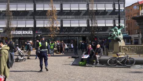 Oficial-De-Policía-Deambulando-Por-Los-Manifestantes-En-Jarntorget-Durante-La-Protesta-Contra-La-Vacuna-Corona-En-Gotemburgo,-Suecia