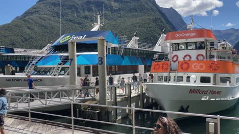 Passagiere-Einer-Tour,-Die-Im-Hafen-Von-Milford-Sound-Ankommen,-Während-Andere-Darauf-Warten,-An-Bord-Eines-Kreuzfahrtschiffs-In-Fiordland,-Neuseeland,-Zu-Gehen