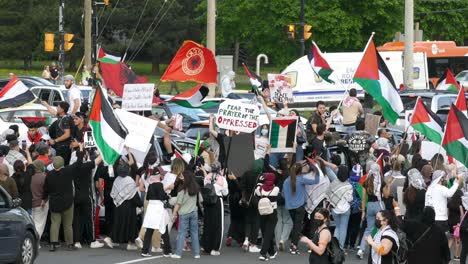 Demonstrators-holding-sign-saying-Fear-The-Prayer-Of-The-Oppressed-and-the-rest-waving-Palestinian-flags-for-pro-Palestinian-rally-in-Mississauga-organized-by-Palestinian-Canadian-Community-Centre
