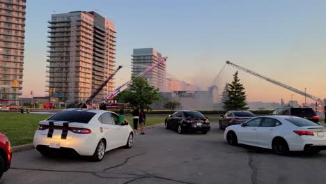 curious-spectators-follow-the-work-of-fire-crews-battling-a-blaze-that-broke-out-at-the-Paramount-Fine-Foods-restaurant-at-the-Erin-Mills-Town-Centre-in-Mississauga,-Ontario,-Canada