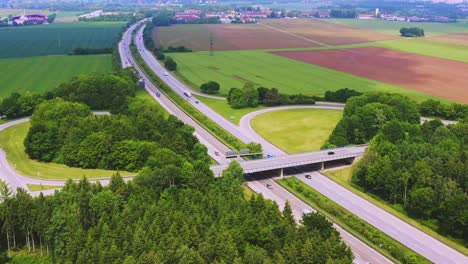 Timelapse-of-a-droneshot-next-to-a-german-Autobahn-with-much-driving-cars,-smootly-zoomed-out-from-the-freeway-scenery