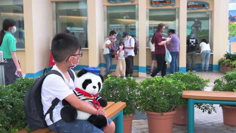 Ein-Junge-Hält-Ein-Ausgestopftes-Tierspielzeug-Am-Eingang-Des-Vergnügungs--Und-Tierthemenparks-Ocean-Park-In-Hongkong