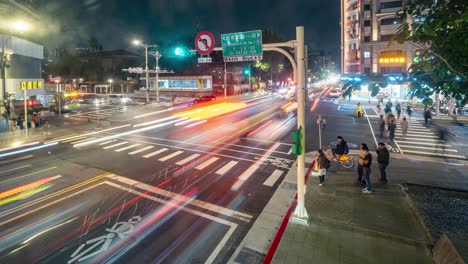 Night-Time-Lapse-Overlooking-at-Zhongxiao-East-Road-intersection-with-Traffics-trails-and-Pedestrians-passing-by-in-busy-Metro-City-Taipei-Taiwan