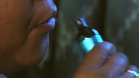 Extreme-closeup-of-young-black-female-millennial-smoking-a-vape-pen