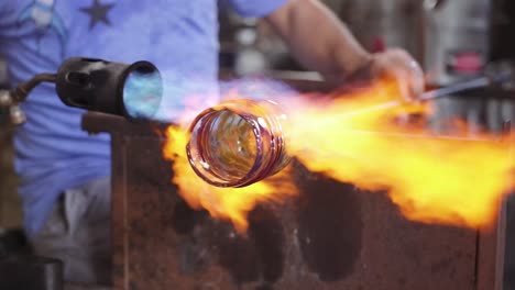 A-glass-blower-heating-a-whiskey-glass-with-fire-flames