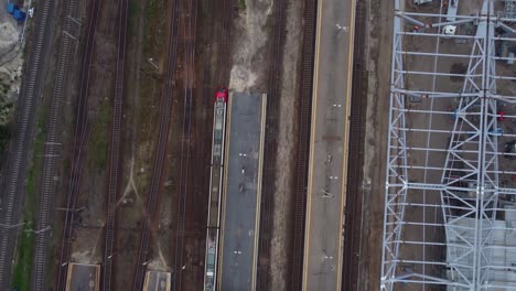 A-drone-video-of-passenger-trains-moving-at-a-train-station-in-Warsaw,-Poland