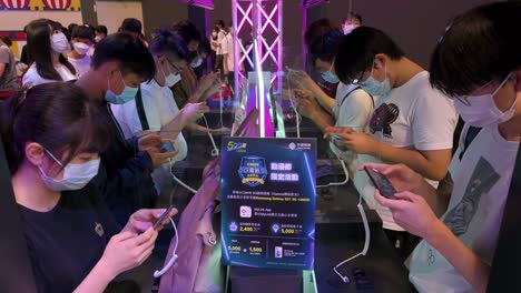 Visitors-play-video-games-on-their-smartphones-during-the-Anicom-and-Games-ACGHK-exhibition-event-in-Hong-Kong
