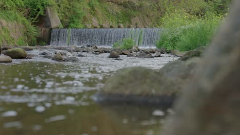 Weir-built-in-rural-river-in-Tottori-Japan,-Rack-Focus-Reveal-Shot