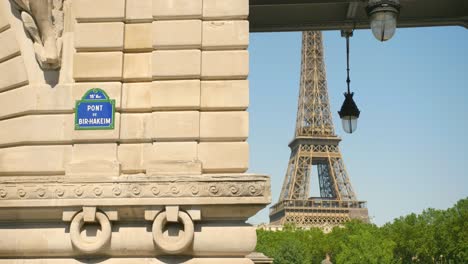 Small-Signpost-Attached-To-Bir-Hakeim-Bridge-With-A-View-Of-Eiffel-Tower-In-Paris,-France