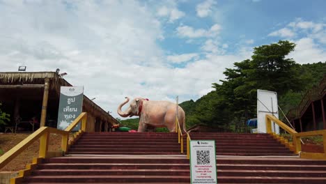 Subiendo-Las-Escaleras-A-Través-Del-Recinto-De-Luang-Pu-Thuat,-Un-Parque-Budista-Que-Revela-Una-Escultura-De-Elefante-Gigante,-El-Símbolo-Del-Budismo-En-Pak-Chong,-Tailandia