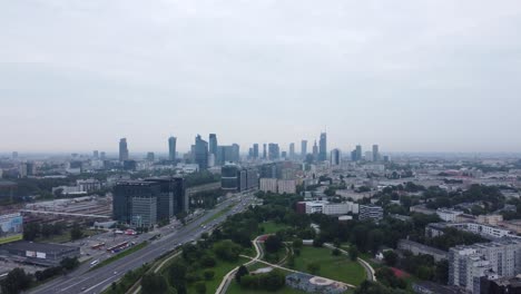 A-drone-video-of-city-road-near-a-park-in-Warsaw,-Poland