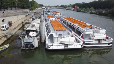 Pan-Shot-Of-Bateaux-Mouches-Parked-On-The-Seine-Waiting-For-Tourists-to-Come-Back-In-Paris-After-Covid-Situation,-France