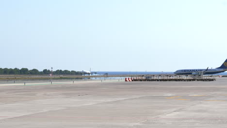 Airplanes-taxiing-and-landing-at-Ibiza-airport,-Spain,-during-summer-season