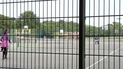 Slow-motion-lady-practice-tennis-on-court-suburban-public-playground