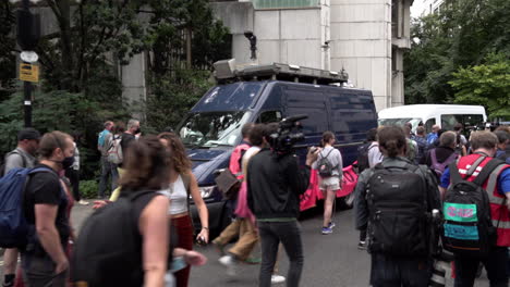 Protestors-march-past-a-blue-van-with-a-facial-recognition-surveillance-camera-on-the-roof-during-an-Extinction-Rebellion-clim-ante-change-protest