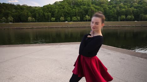 Attraktive-Kaukasische-Tänzerin,-Die-An-Einem-Warmen-Sommerabend-Vor-Einem-Fluss-Tanzt