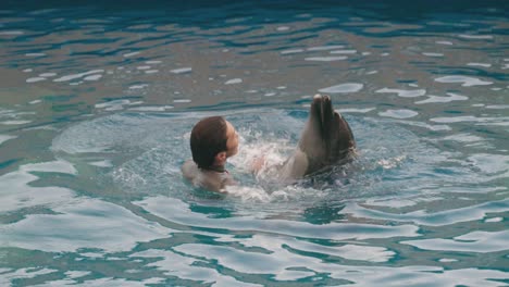Delphin-Mit-Männlichem-Trainer,-Der-Im-Wasser-Tanzt-Und-Sich-Dreht,-Für-Das-Publikum,-Das-Eine-Delphinshow-Im-Umino-mori-aquarium-In-Sendai,-Miyagi,-Japan,-Sieht