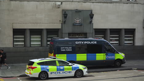 A-police-car-and-van-parked-outside-a-police-station-in-central-London