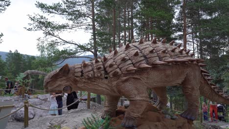 Ankylosaurus-dinosaur-Zuul---Real-to-life-recreation-inside-Norwegian-theme-park-Bjorneparken---Handheld-static-clip-with-children-and-families-around-dinosaur