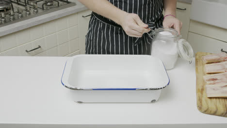 Adding-salt-into-a-cooking-tray-with-water
