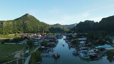 Descending-aerial-footage-revealing-a-boat-coming-down-the-river,-beautiful-picture,-Bang-Pu-Fishing-Village,-Sam-Roi-Yot-National-Park,-Prachuap-Khiri-Khan,-Thailand