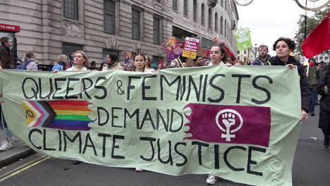 Protestors-with-a-banner-that-says,-“Queers-and-Feminists-Demand-Climate-Justice”-march-with-thousands-on-the-Global-Day-For-Climate-Justice-demonstration-as-the-Cop-26-summit-is-held-in-Glasgow