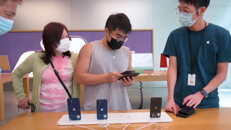 Am-Tag-Der-Markteinführung-Der-Neuen-Smartphones-Der-IPhone-13-Serie-In-Hongkong-Werden-Käufer-Dabei-Beobachtet,-Wie-Sie-Produkte-Der-Marke-Apple-In-Einem-Apple-Store-Testen