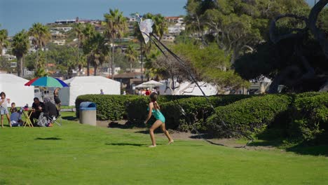 Young-girl-in-a-park-trying-to-launch-a-kite,-Slowed-to-half-speed