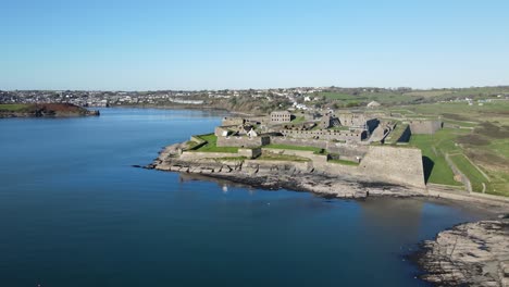 An-aerial-panorama-on-a-sunny-day-from-the-ocean-side-over-to-Kinsale,-Charles-Fort-and-harbour