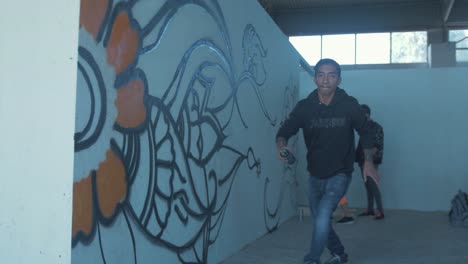 Young-male-Nepali-graffiti-artist-jumps-in-excitement-in-front-of-graffiti