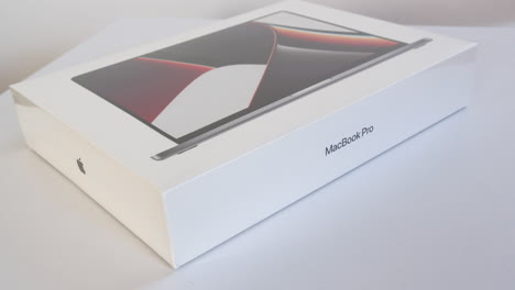Nueva-Caja-Apple-M1-Macbook-Pro-Girando-En-Escritorio-Blanco