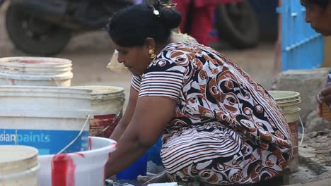 Close-up-of-a-lady-washing-clothes-in-the-streets-of-Chennai,-India