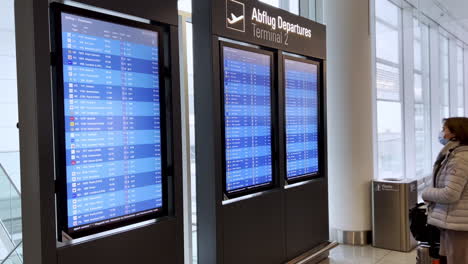 Passagiere-Des-Flughafens-München-Lesen-Die-Flugtafel-Auf-Dem-Fluginformationsanzeigesystem-Am-Flughafen-München