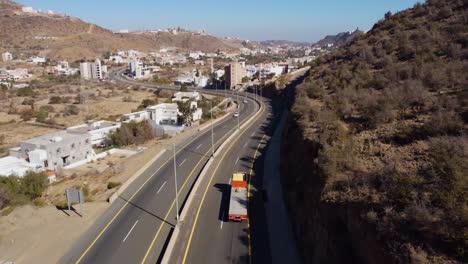 Aerial-drone-view-following-a-lorry,-driving-on-a-road-in-Al-baha,-Saudi-Arabia