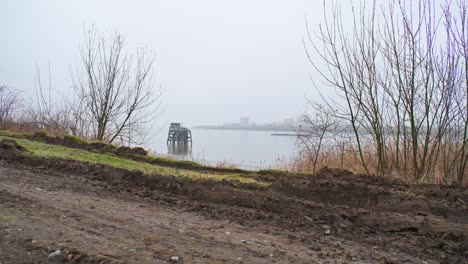 Foggy-misty-cloudy-day-river-Schelde-big-cargo-ship-passing-by-in-the-distance
