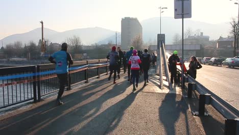 Grupo-De-Velocistas-Corriendo-Una-Maratón-A-Través-Del-Puente-En-La-Fría-Mañana-De-Enero