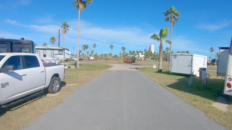 POV-thru-rear-window-while-driving-through-campground-in-Isla-Blanca-Park-on-a-sunny-winter-day