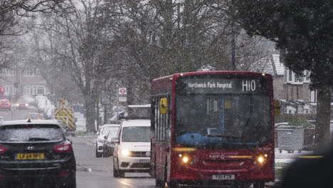 Red-H10-London-Bus-Driving-Past-In-Snow-In-London
