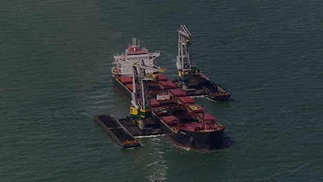 aerial-view-of-Cranes-offloading-a-dredger-ship-in-the-water