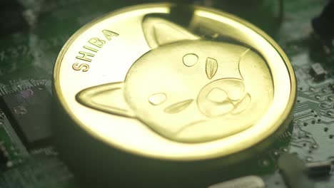 Detail-of-physical-Shiba-Inu-metal-coin-with-bluish-coloring-on-electronic-circuit-board