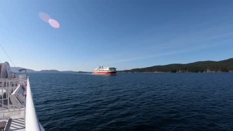 Halhjem-Sandvikvaag-ferry-meet-cruise-liner-Bergensfjord-from-Fjordline-company-outside-Bergen---Static-filmed-from-ferry-Lysoy-with-Bergensfjord-approaching-ships-side