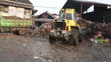 Excavator-lifts-garbage-from-landfill-to-truck