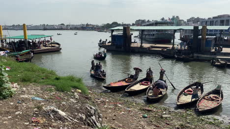 Pan-shot-of-river-bank-of-buriganga-with-some-wooden-boats-and-jetty