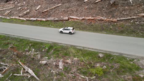 Ein-Einsamer-Weißer-Subaru-Crosstrek-Fährt-Durch-Ein-Abgeholztes-Waldgebiet,-Luftstrecke,-Illustrativer-Leitartikel