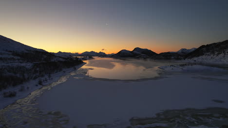 Moody-sunset-high-fly-over-frozen-fjord-during-the-polar-night-season---Northern-Norway---Scandinavia---Jornfjorden
