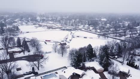 4K-drone-video-of-snow-covered-baseball-field-at-a-school-in-winter-in-suburbs-of-Grand-Rapids,-Michigan