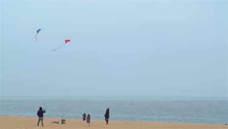 Family-with-children-flying-kites-on-the-beach-in-Barcelona